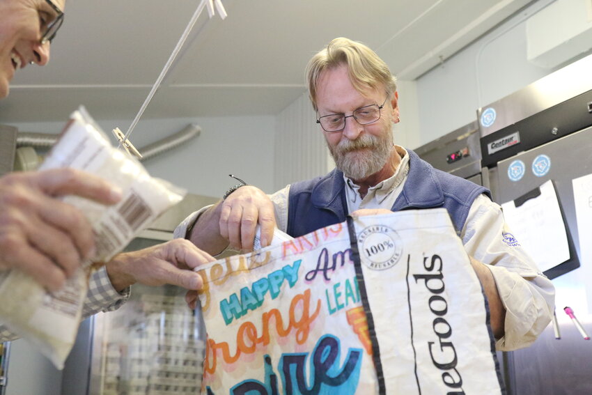 Joe Huber, left, and Shane Amos fill bags with groceries at the Nantucket Food Pantry Tuesday afternoon.