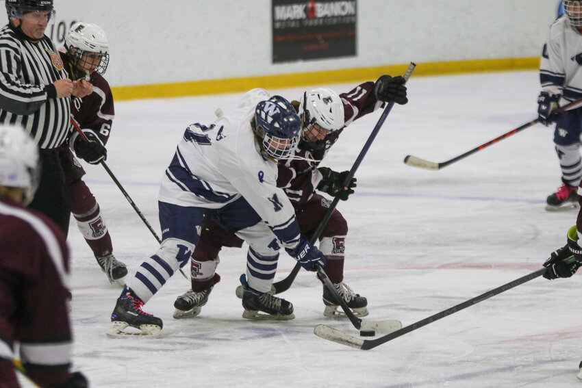 Emerson Pekarcik, left, battles for the puck with a Falmouth player Saturday.