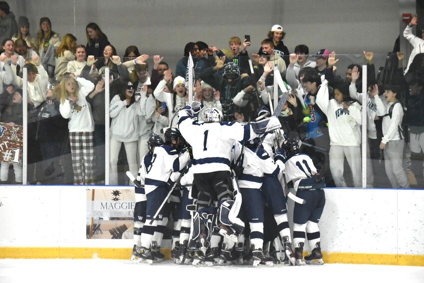 The boys hockey team celebrates after a playoff victory over Abington.
