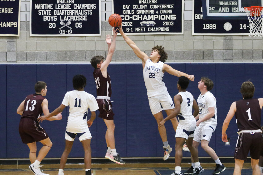 Oliver Marrero (22) blocks a shot during the boys basketball team&rsquo;s 63-41 win against Falmouth at home Saturday. The sophomore scored two points off the bench in the victory.