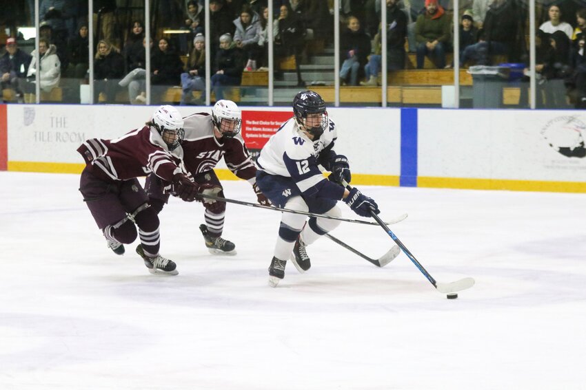 Ryan Davis, right, skates past two Bishop Stang players during the Whalers' 5-0 win Saturday.