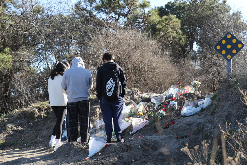 Students on Tuesday place flowers and other mementos at the site of the Bartlett Road crash that killed Christopher Lemus, 17.