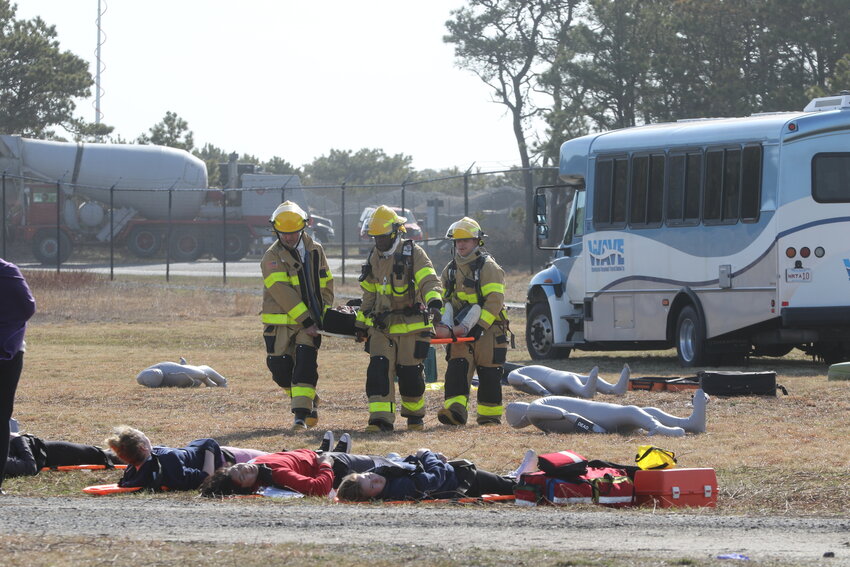 Firefighters from the Nantucket Memorial Airport ARFF team carry a crisis actor from Nantucket High School.