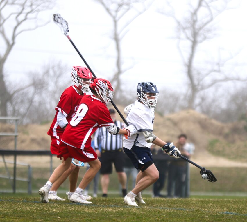 Hunter Strojny, right, spins away from two Barnstable players during the Whalers' 13-5 win in Thursday's home opener.