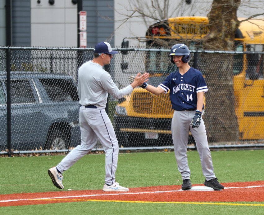 Alex Horton, right, high-fives coach Jack Pearson after reaching third base Saturday against Boston Latin Academy.
