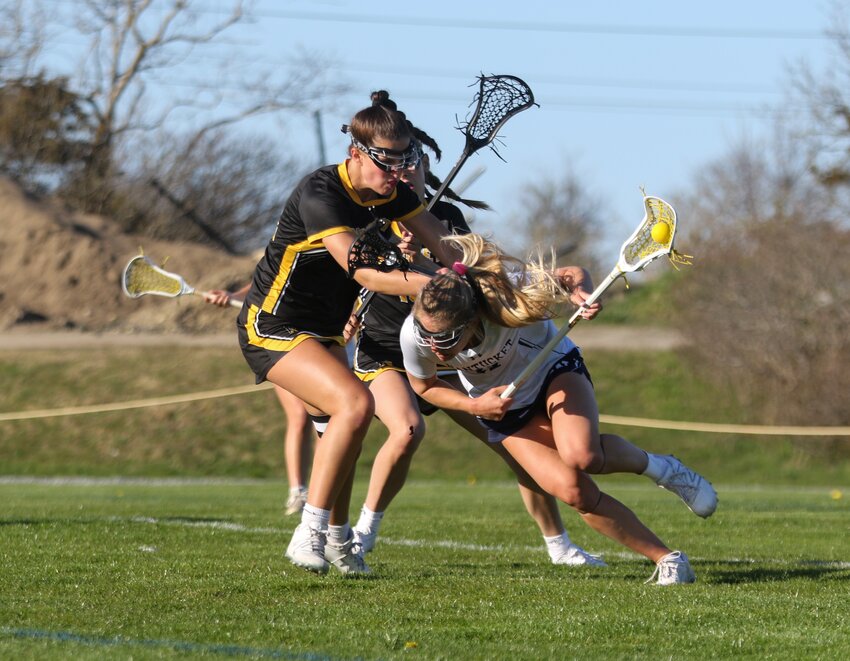 Bailey Lower, right, ducks under a stick check by a Nauset player in the Whalers&rsquo; 17-6 home win Monday. The senior midfielder scored nine goals in the victory.