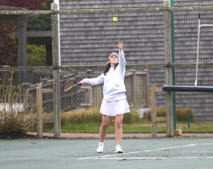 Joan Harris tosses up a serve Monday against Dennis-Yarmouth.