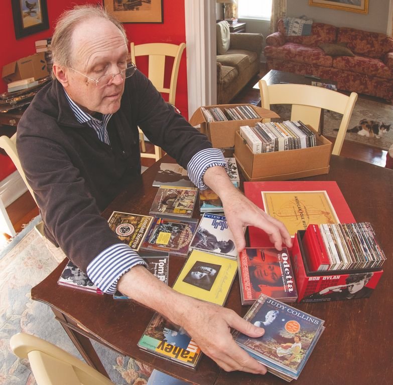 Former record-store owner and Rolling Stone album-reviewer Charley Walters sifts through a stack of CDs in preparation for a class he's teaching at the Atheneum on folk music.