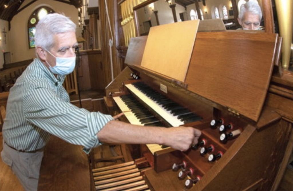 Joe Hammer, director of music at St. Paul's Episcopal Church, works the levers and keys of the church's historic Hutchings-Votey 1902 pipe organ.