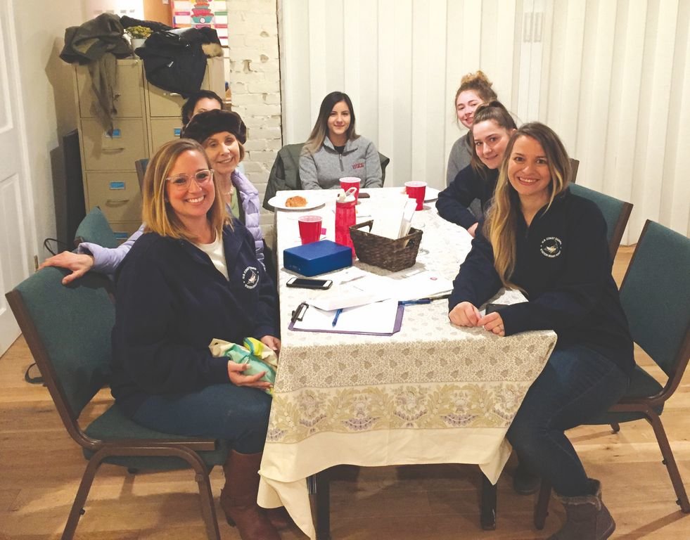 Members of the Station Brant Point Spouses Organization with Unitarian minister Linda Simmons, back left, during a donation day at the Unitarian Meeting House in early January.