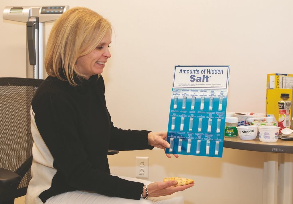 Dietitian Suzanne Davis holds a chart showing the hidden salt found in common foods and sauces in her office at Nantucket Cottage Hospital this week.