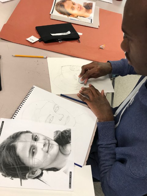 Rushawn Leamy works on his portrait of a Syrian girl as part of the Memory Project in Merrill Mason's high-school art class.