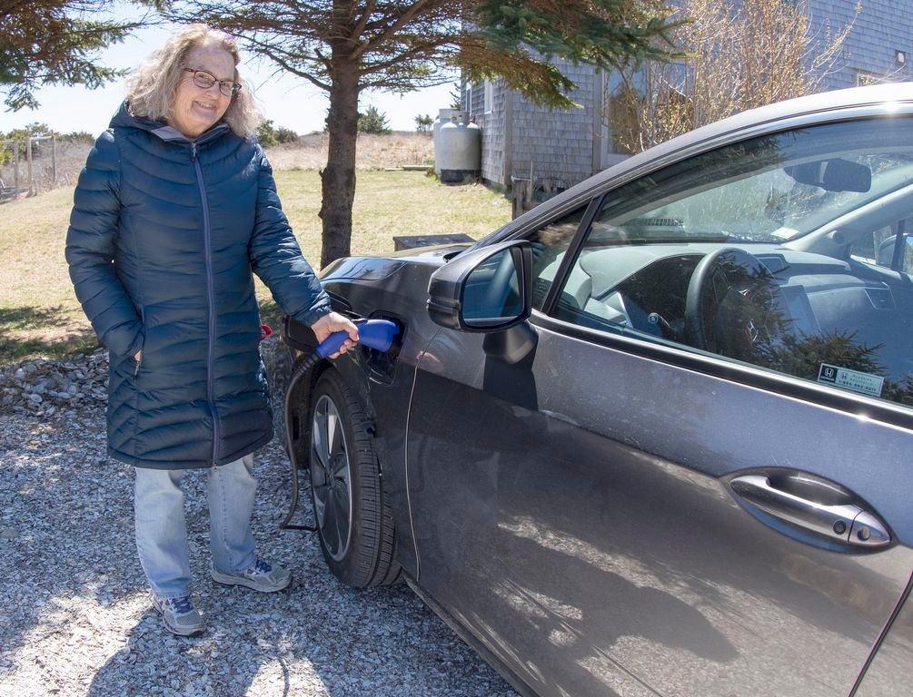 Barbara White plugging in her Honda Clarity electric car at her home on Pochick Avenue.