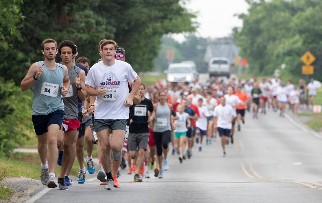 Runners head out on the route of the Firecracker 5K road race on Old South Road Sunday morning.