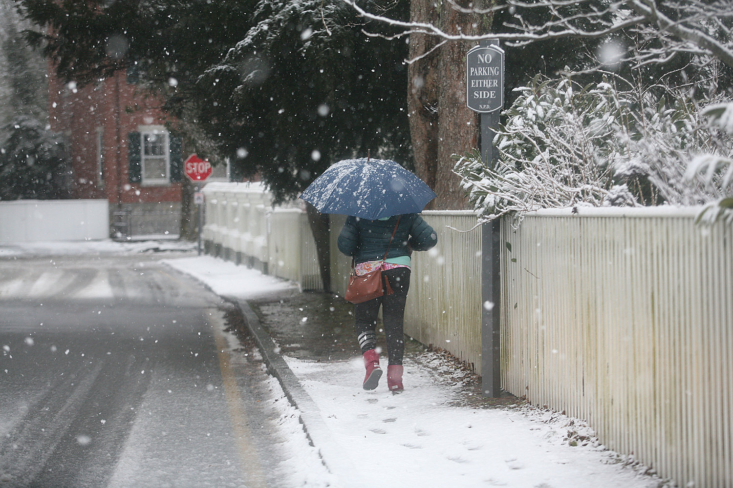 WINTER SCENES -- February 7, 2021 --A woman walks along Pleasant Street during Sunday's snow storm.  Photo by Ray K. Saunders