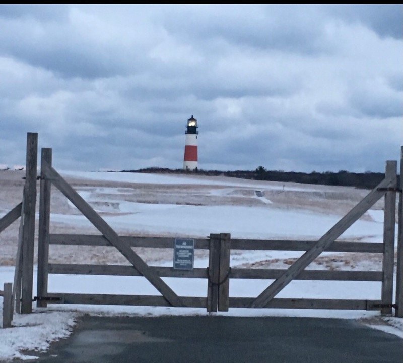 Snow covers the ground around Sankaty Head lighthouse.