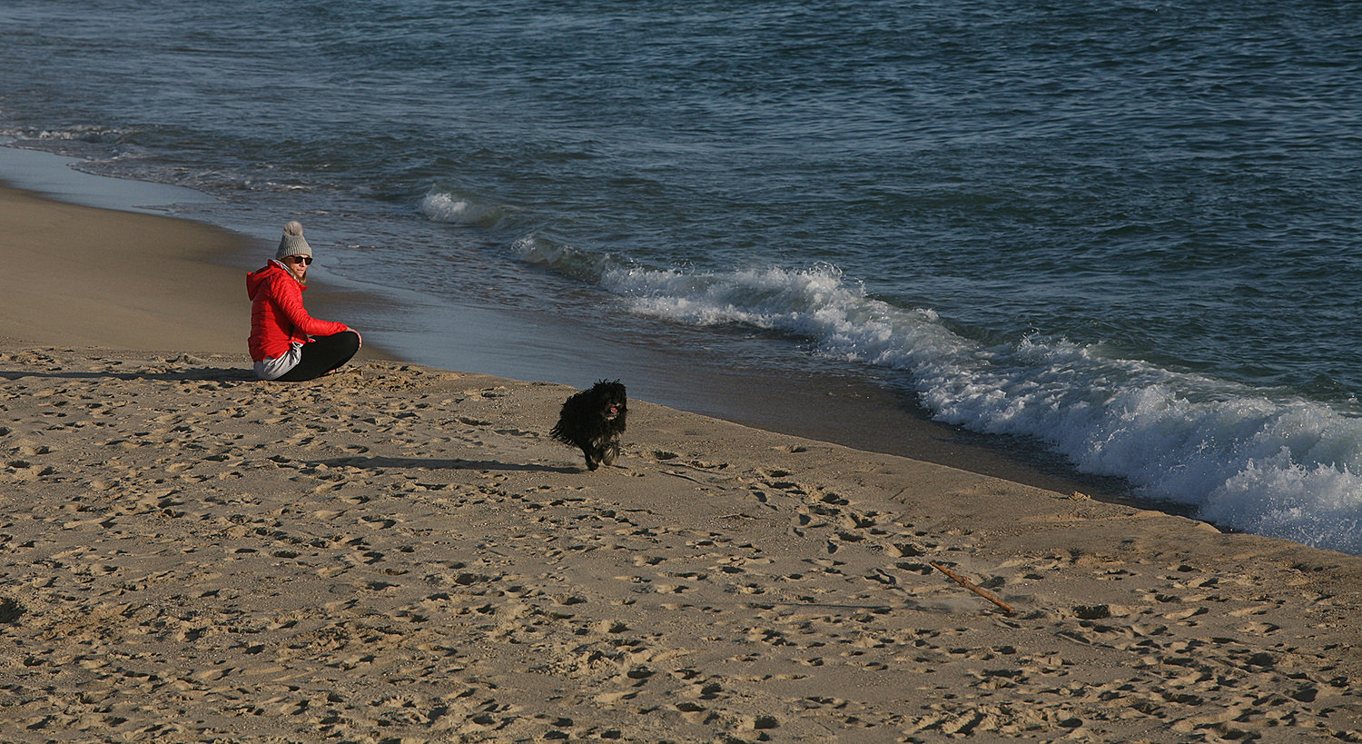 Mairi Lindsay, of Nantucket, plays fetch with her dog at Cisco Beach on Monday.