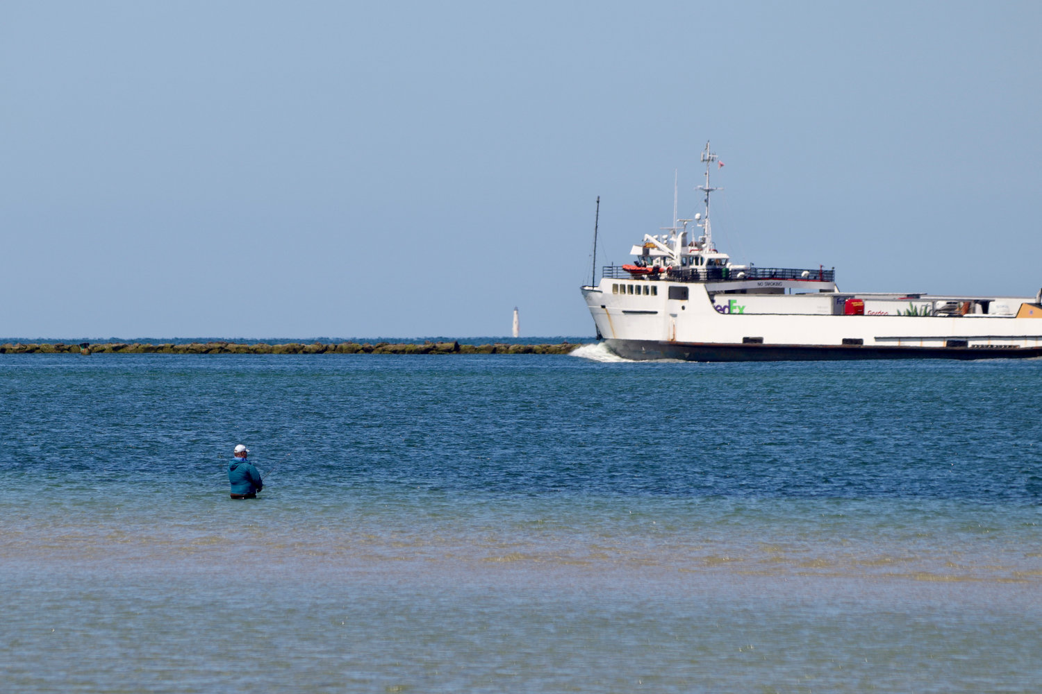 A fisherman casts into Nantucket Harbor south of the west jetty May 24.