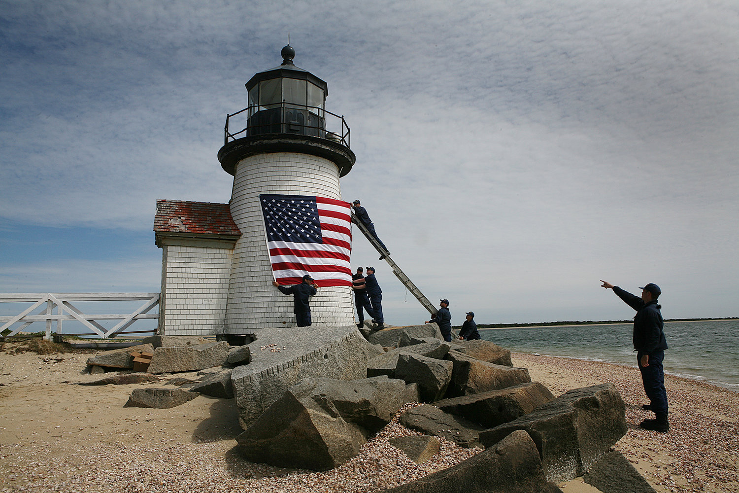 MAY 28, 2021 -- A crew from the US Coast Guard Station Brant Point takes down the daffodil wreath and puts up a flag in honor of Memorial Day and the Fourth of July at the Brant Point lighthouse.