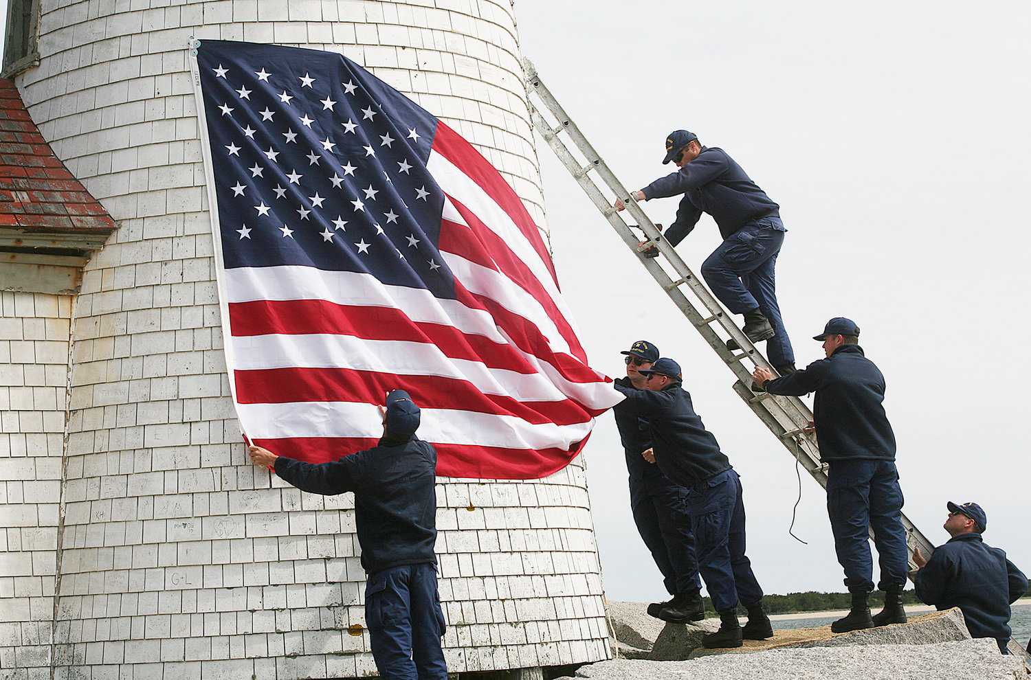 A crew from the US Coast Guard Station Brant Point takes down the daffodil wreath and puts up a flag in honor of Memorial Day and the Fourth of July at the Brant Point lighthouse.