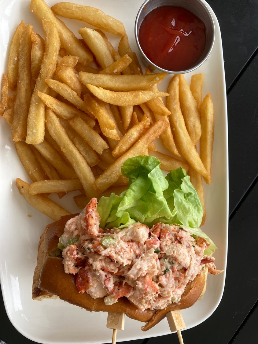 Classic lobster roll on a buttered bun with French fries from Brant Point Grill
