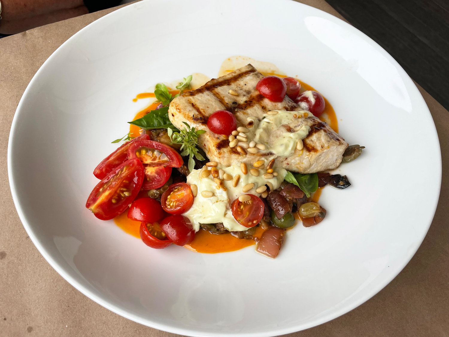 Straight Wharf Restaurant’s swordfish is grilled over a wood fire and served with an eggplant caponata, and garnished with cherry tomatoes, pine nuts and a caper aioli.