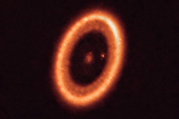 This ALMA image of the PDS 70 system shows the large dust ring that circles the star as well as the dusty glow around the planet PDS 70c, which appears as a bright spot in the large gap.