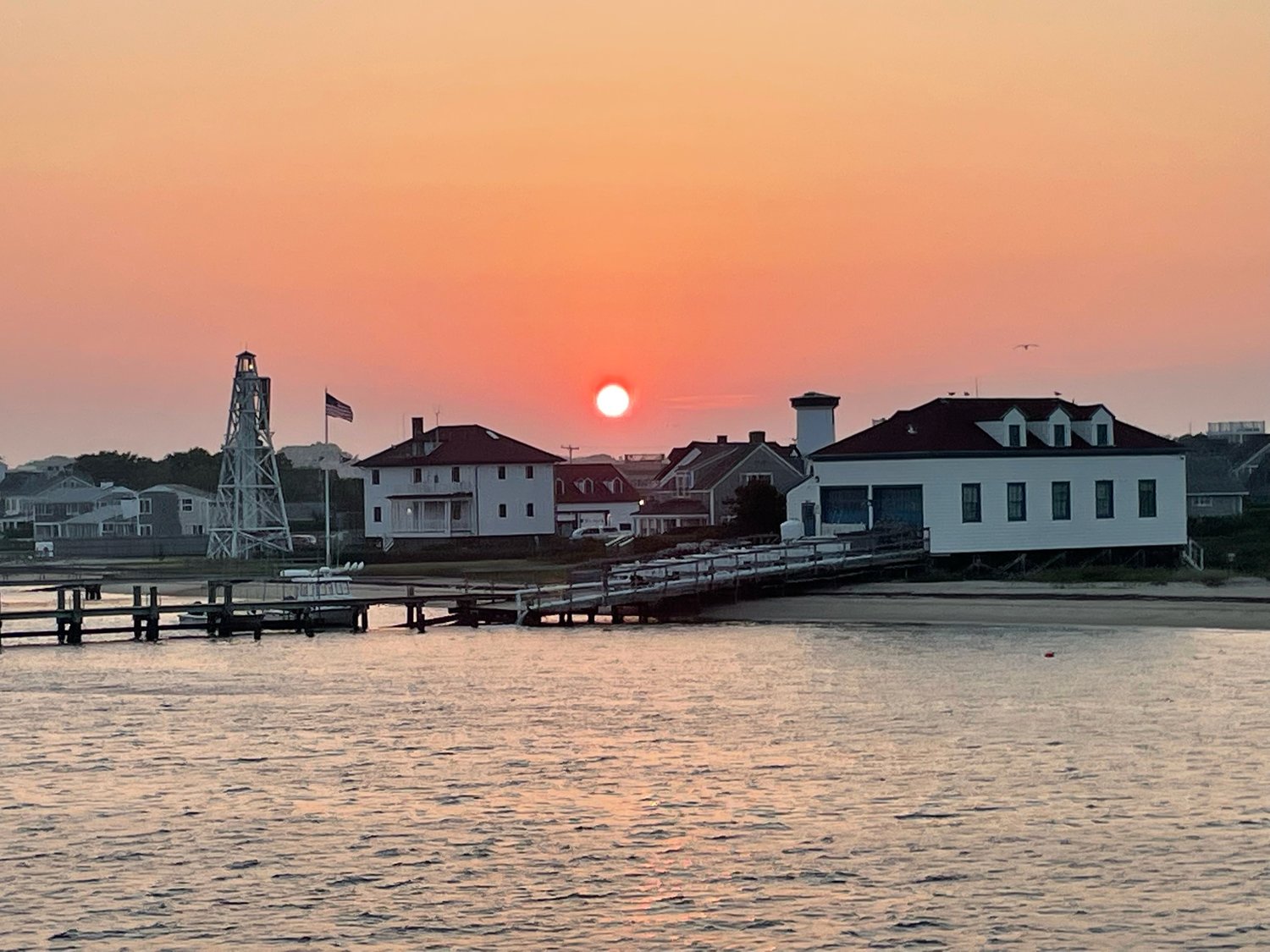 The sun sets over Brant Point as seen from the departing ferry.