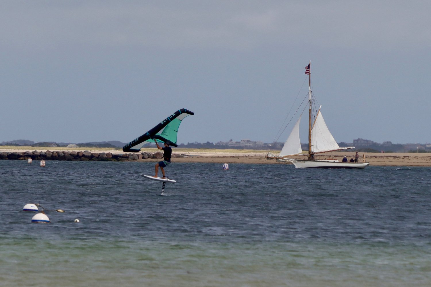The new and old way of harnessing wind power. An unidenified windsurfer with the sailboat Endeavor heading out of the channel Monday afternoon.