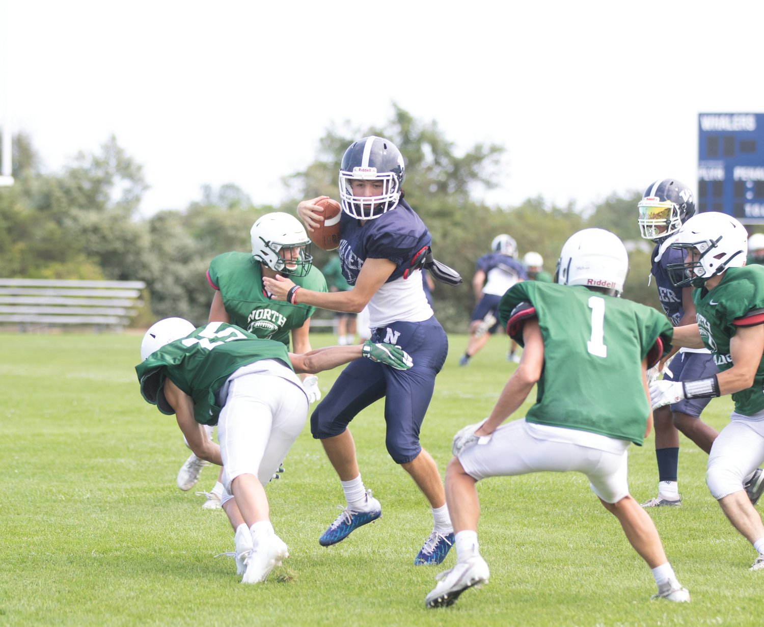 Sophomore quarterback Carlos Aguilar dodges a gang of North Reading tacklers in Saturday’s home scrimmage.