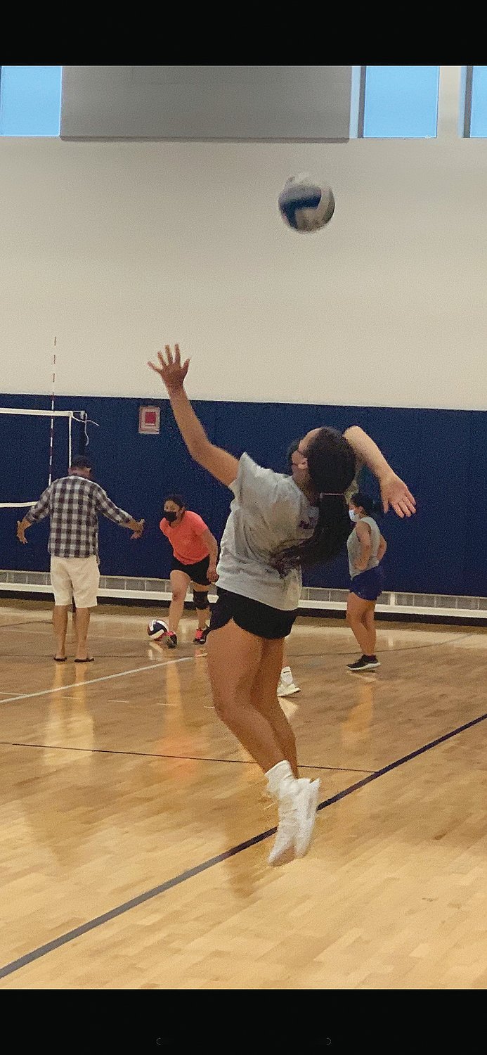 Senior Yvie Scarlett prepares to return the ball during varsity volleyball practice Monday.