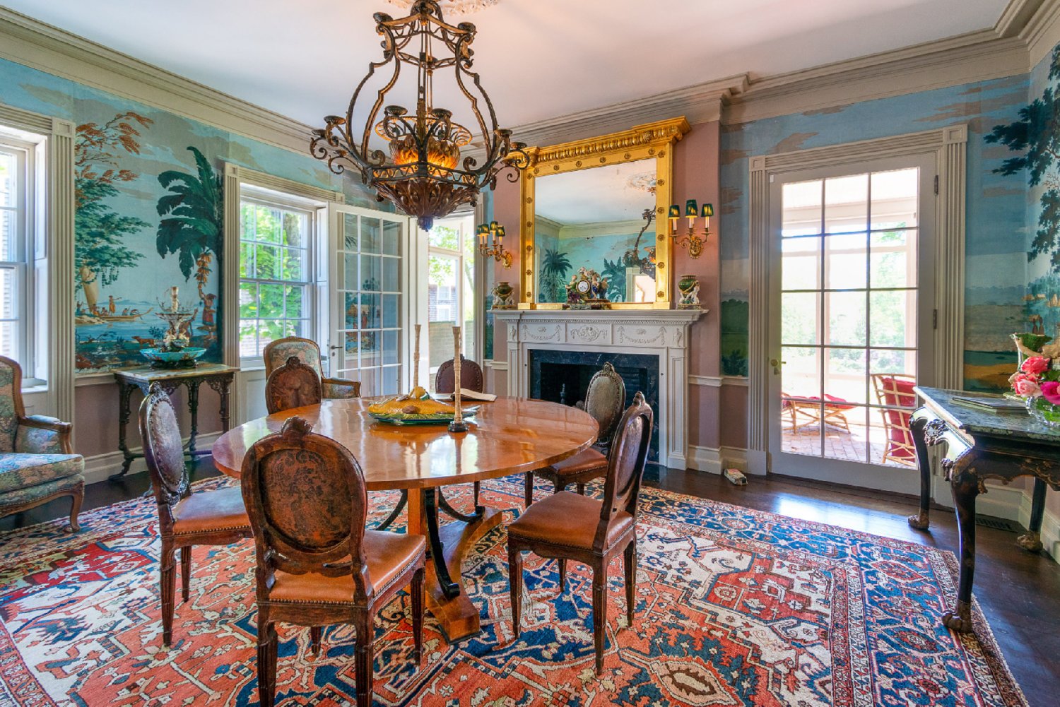 The formal dining room has a wood-burning fireplace and hand-painted French wallpaper illustrating Capt. James Cook’s South Seas sailing voyages.