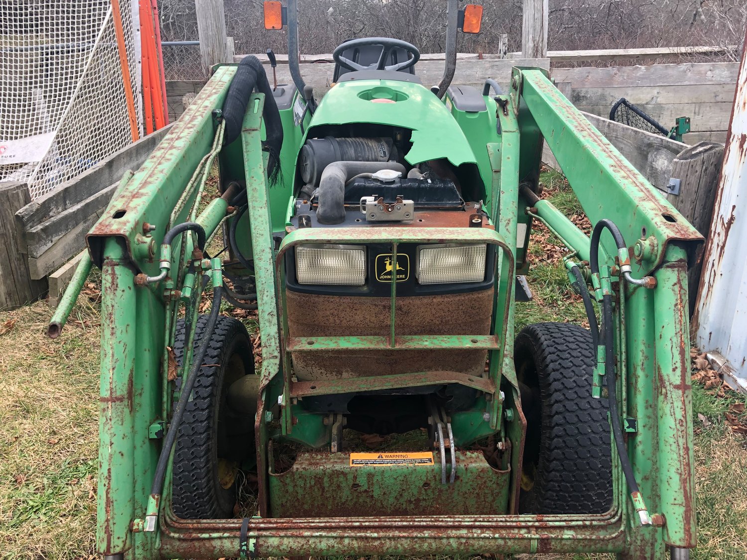 The plastic cowling over the engine on this John Deere tractor was heavily damaged.