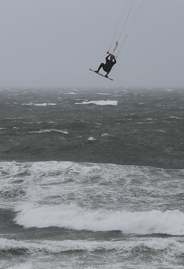 A kite surfer is lifted high in the air over the surf kicked up by Tropical Storm Elsa at Cisco Beach on July 9.