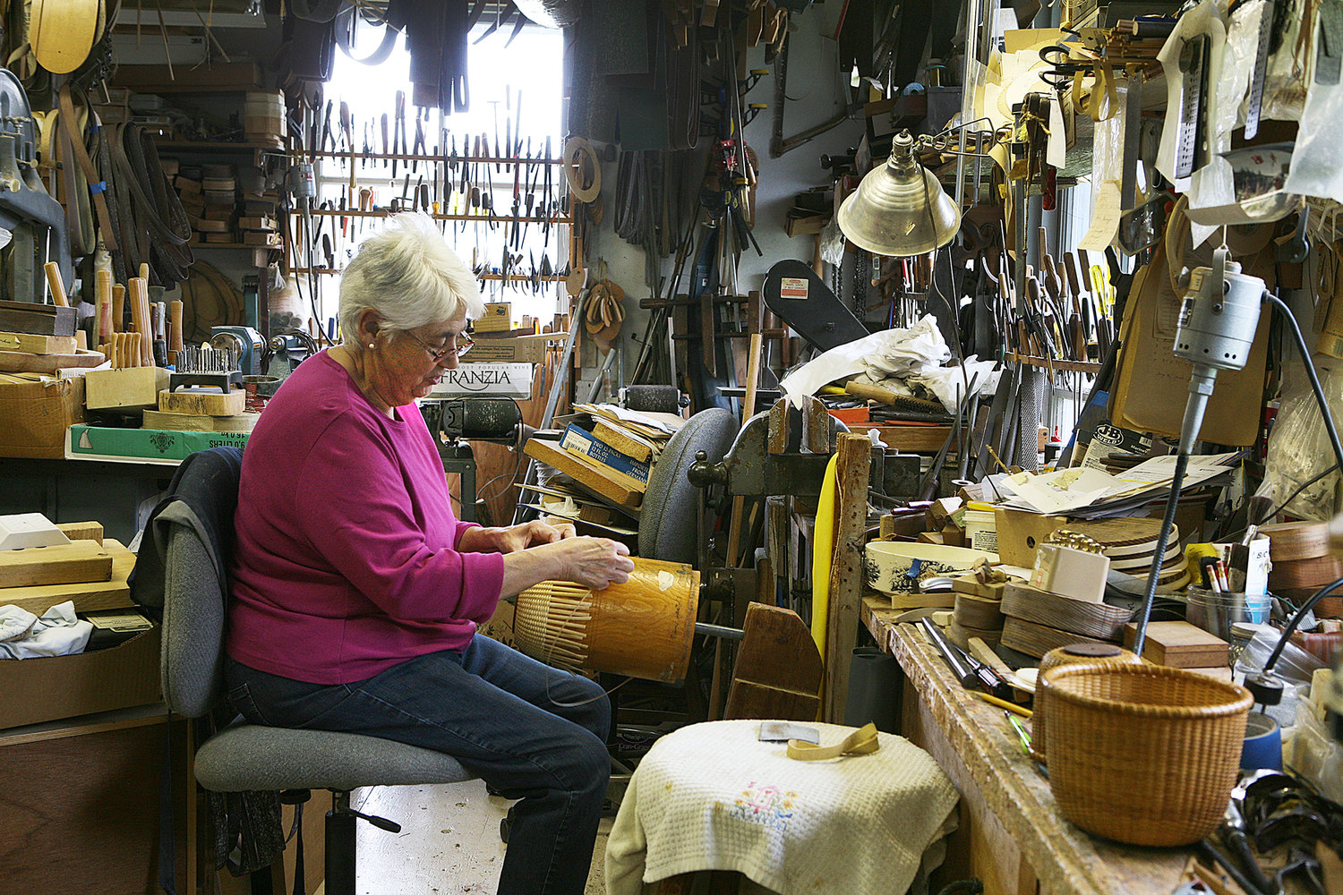 Island basket maker Susan Ottison works on a basket in the shop she shares with her husband Karl on Orange Street.