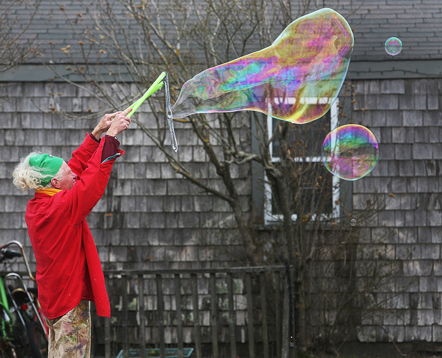 Nantucket artist Matthew Oates creates large bubbles on an early Spring Saturday at the corner of Washington and Francis streets. Oates watched the bubbles drift over Washington Street toward the harbor, entertaining drivers on Washington Street. Oates said that doing this was "a destresser."
