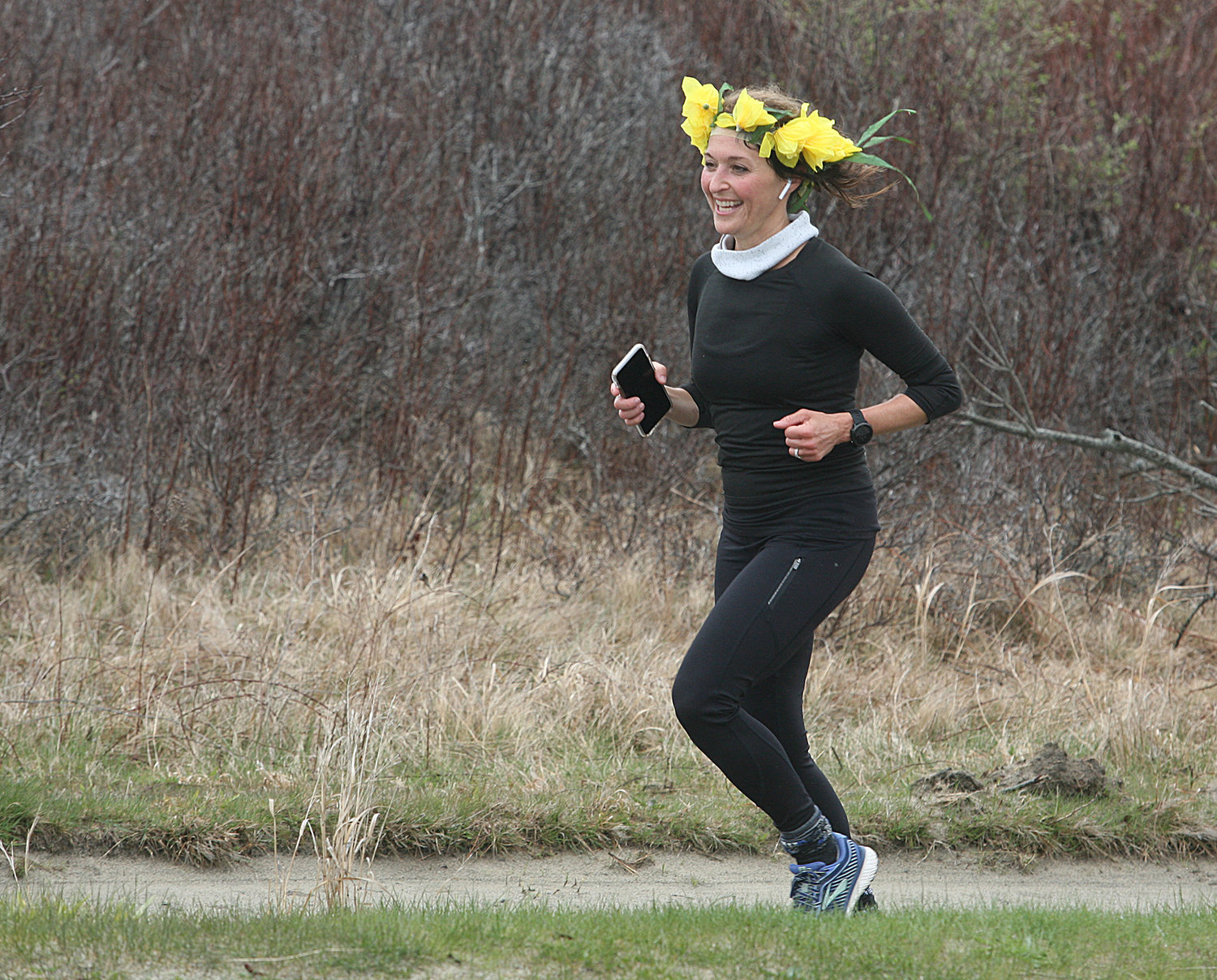Alexandra Glazier, of Nantucket, is all smiles wearing a daffodil crown as she nears the finish line on the path along Dionis Beach Road on in April. It was Glazier's 50th birthday and she ran a personal 10K trying for her best time. She succeeded.