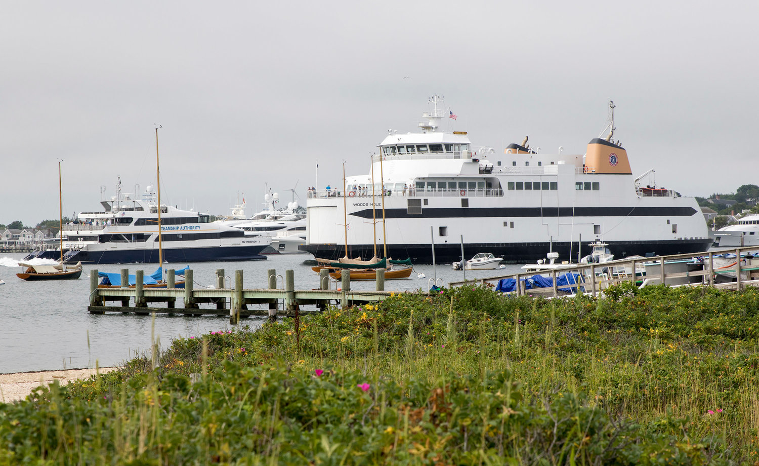 The Steamship Authority car ferry Woods Hole leaves its berth while the fast ferry Iyanough arrives in Nantucket Harbor.