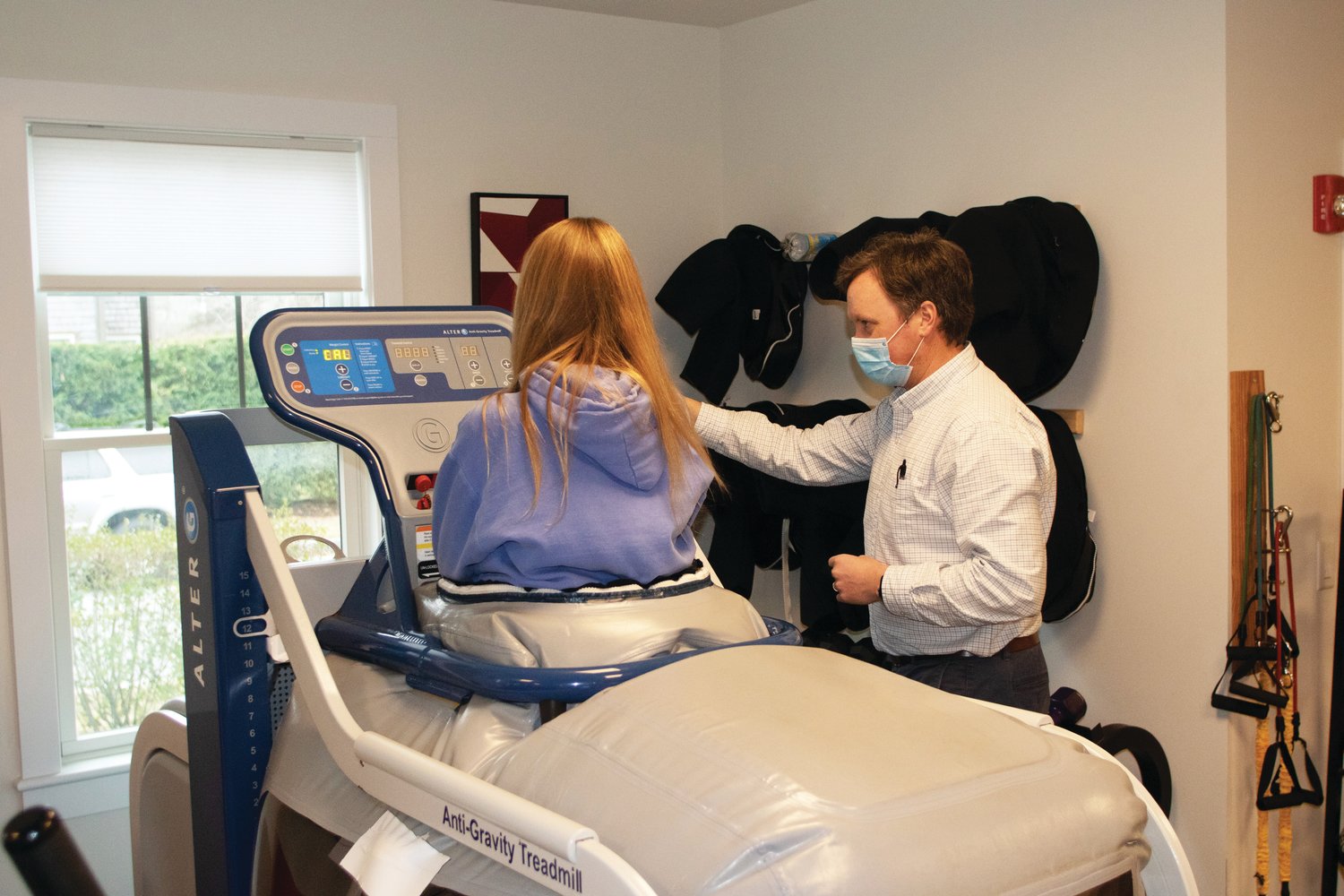 Physical therapist Joe Manning works with a client on an anti-gravity treadmill in his Amelia Drive office.