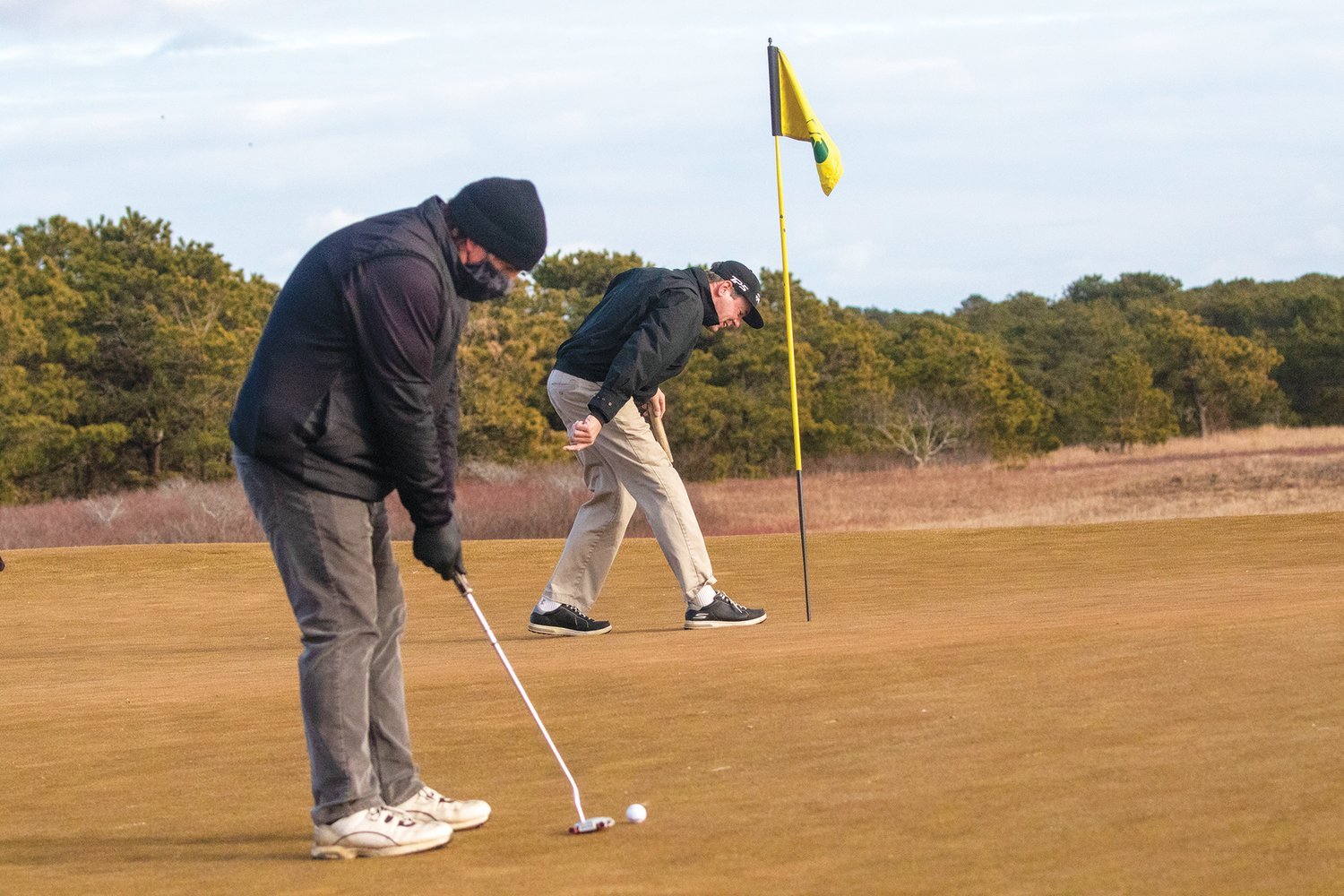 David Macaulay lines up a putt while Jim Wiemann retrieves his ball from the hole during a round of winter golf at the Miacomet Golf Course last week. Off-season play at Miacomet is up significantly over past years.