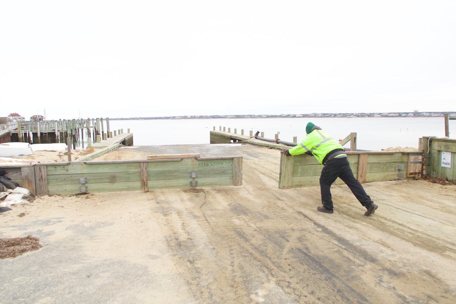 A Department of Public Works employee closes the storm gate at the Children's Beach boat ramp Friday afternoon.
