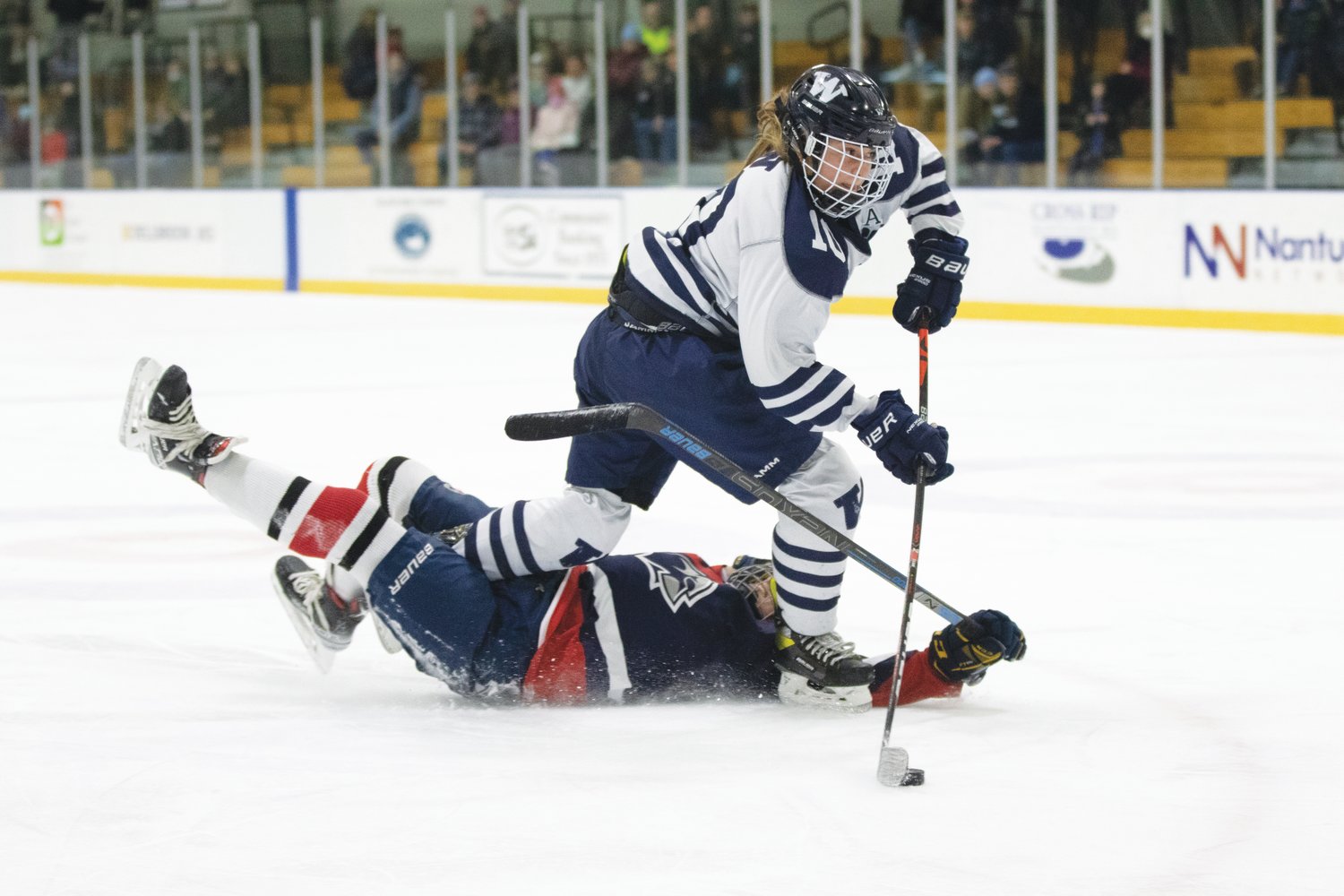 Claire Misurelli levels a Brookline player and stays up with the puck.