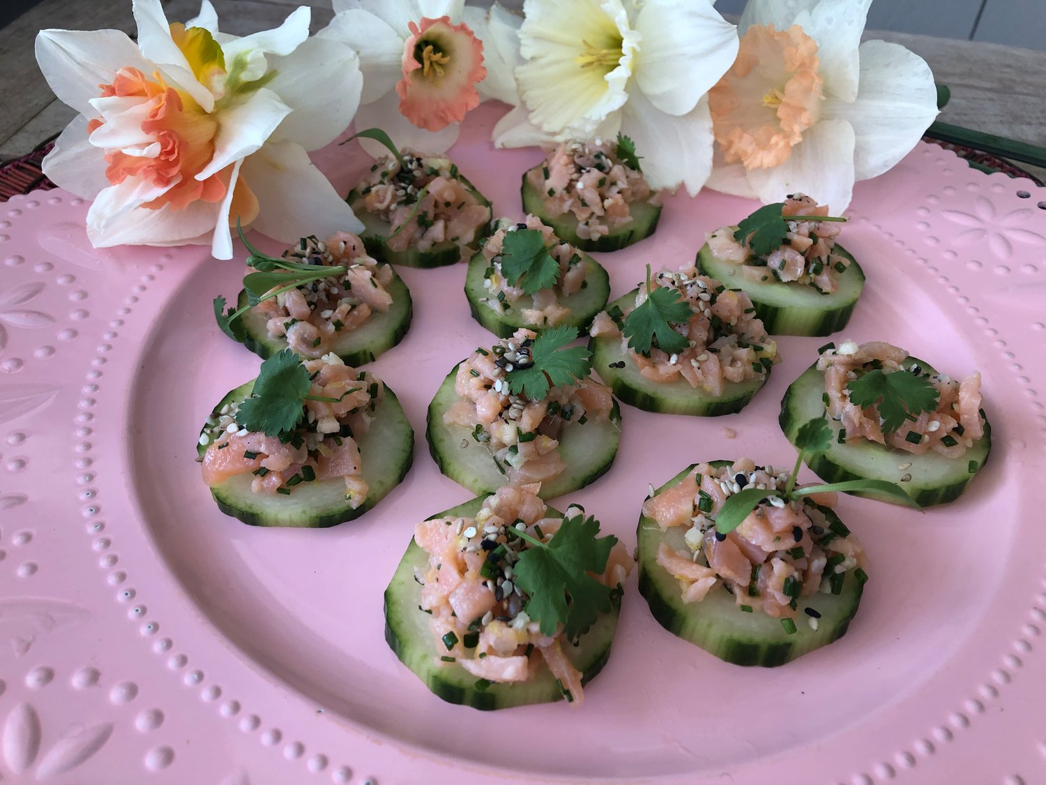 Smoked Salmon Tartare, served on cucumber rounds with sprigs of cilantro.