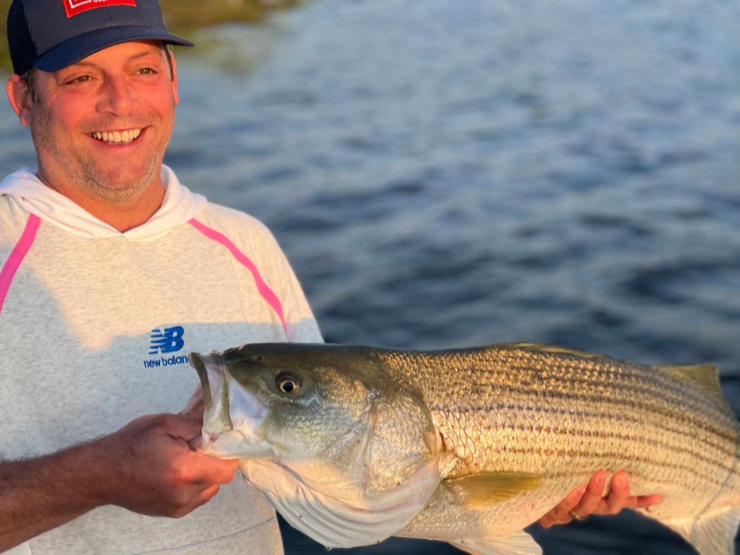 Alex Migel with a big striped bass he caught in the harbor