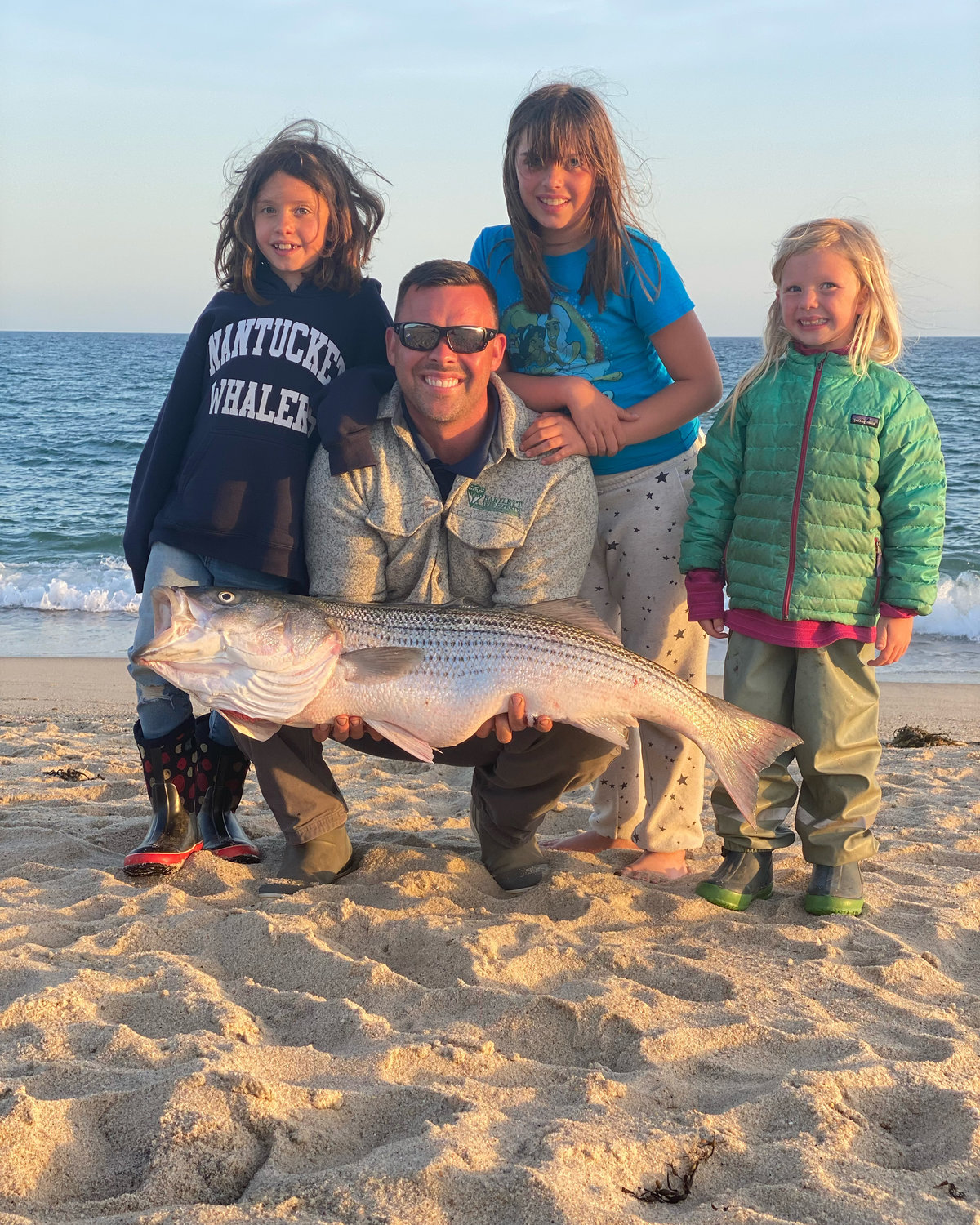 Jim Cook and his family with a striper they caught on the south shore this weekend.