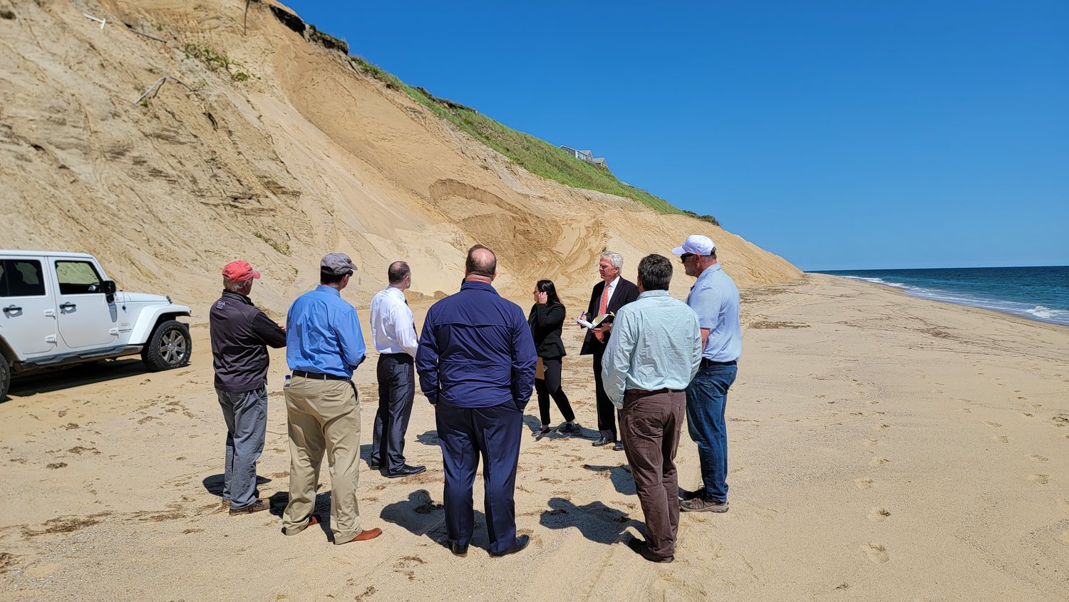 Superior Court Judge Mark Gildea at the foot of the Sconset Bluff Tuesday on a site visit accompanied by members of the ConCom and SBPF, on opposite sides of a lawsuit concerning removal of the geotubes protecting the bluff.