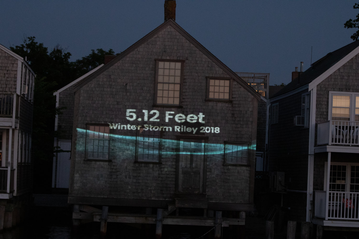 "Rising Above," a public art installation to bring attention to climate change and sea-level rise,  projected on a building at Old North Wharf Wednesday.