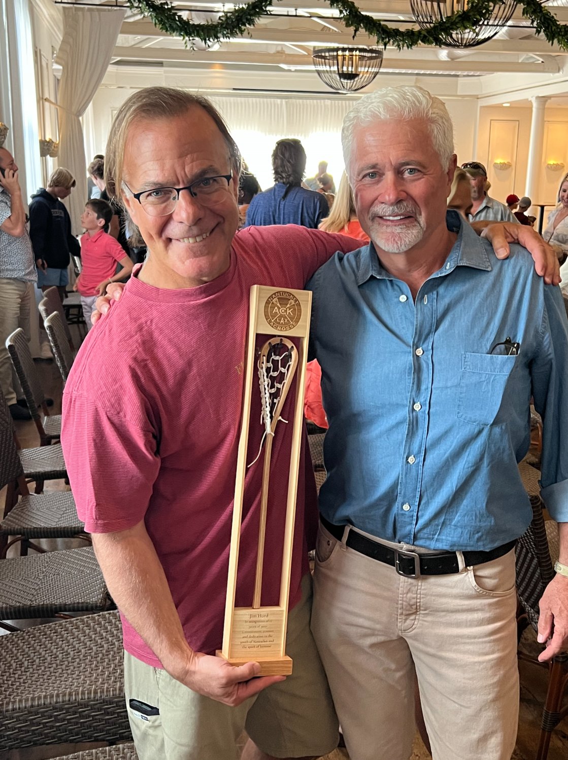 Outgoing Nantucket Student Lacrosse president Jim Hurd (left) holding his handcrafted award alongside incoming president Gary McCarthy.