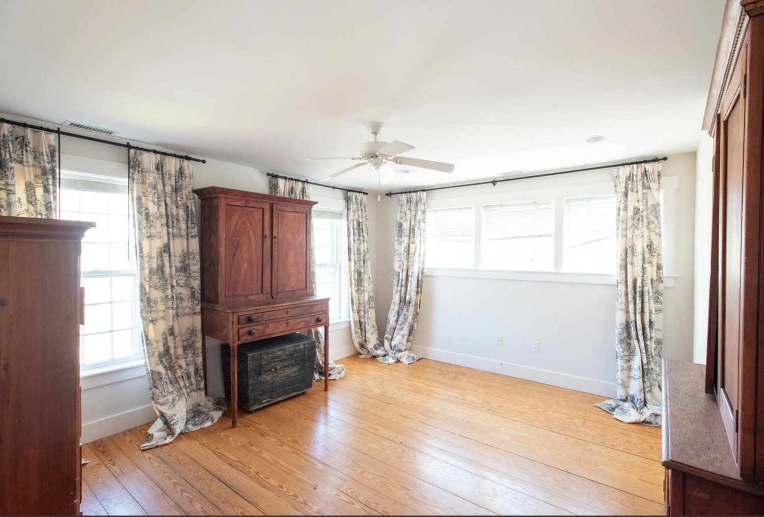 The bright and airy rooms have wood floors and multiple windows.