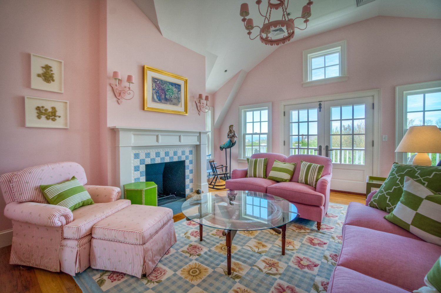 This second-floor sitting room has a fireplace, cathedral ceiling and a balcony with water views.
